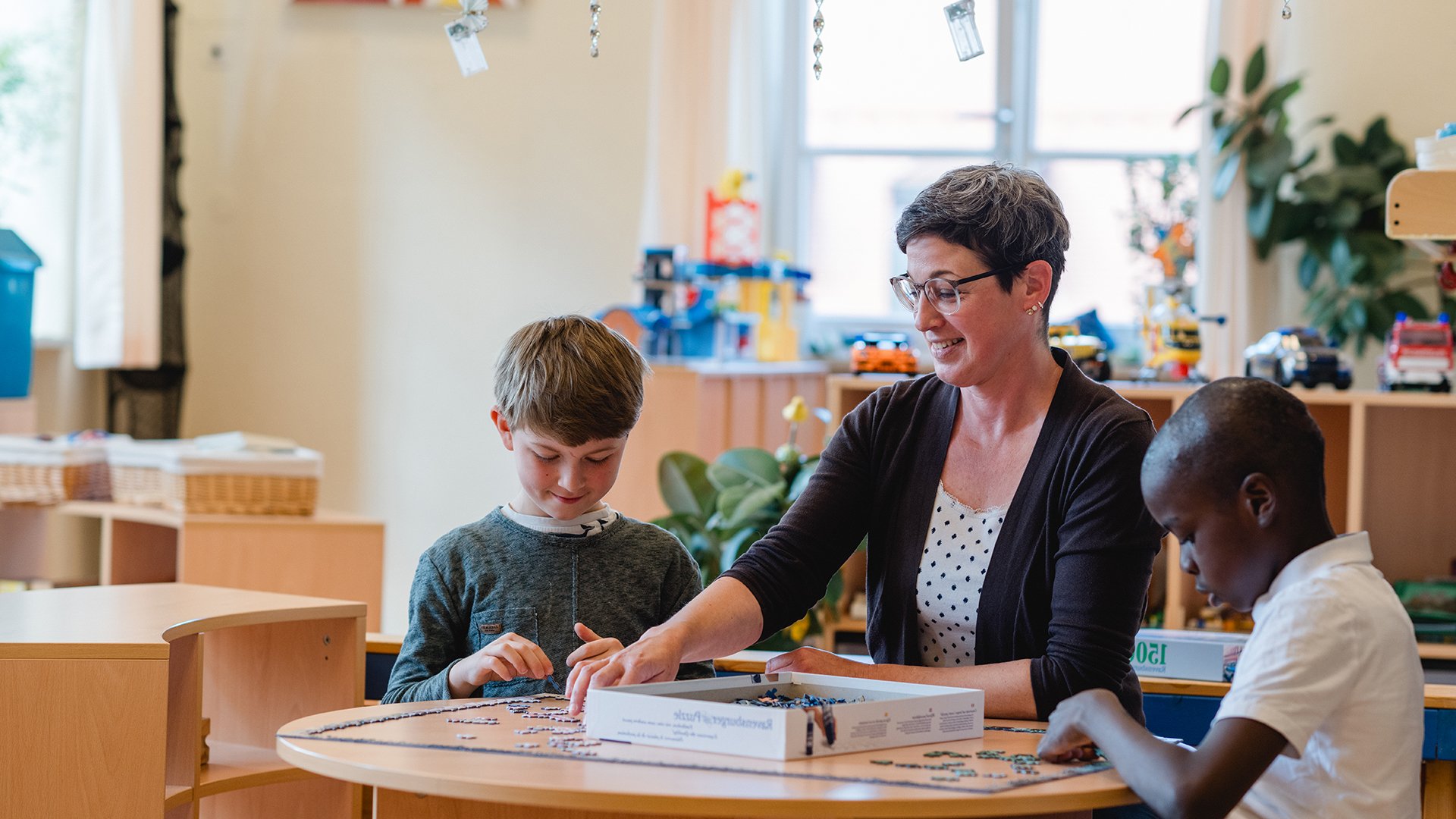 Kinder mit Pädagogin in Spielsituation